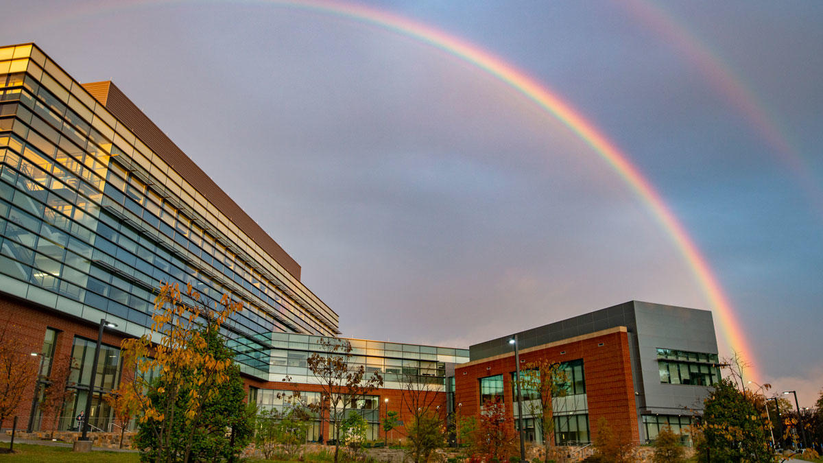Peterson Hall on the Fairfax Campus of George Mason University with a double rainbow in the sky.
